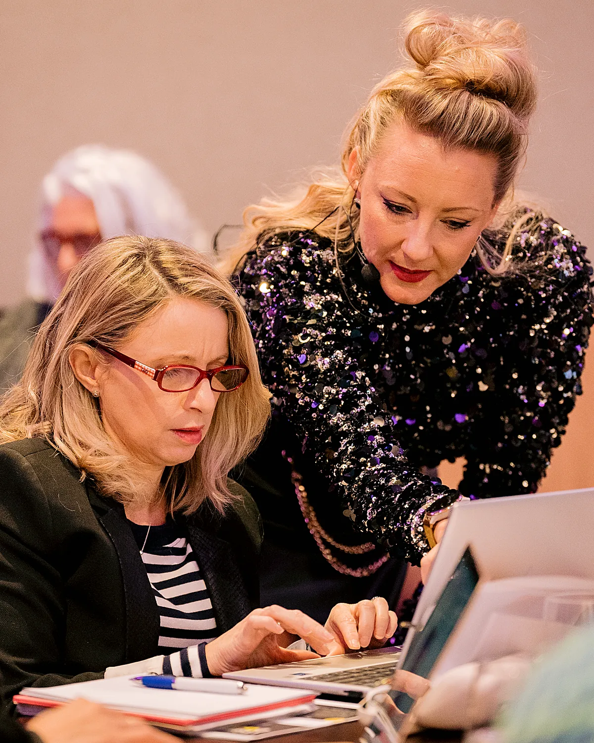 Sarah Cordiner leaning over a client's laptop helping them build their tech