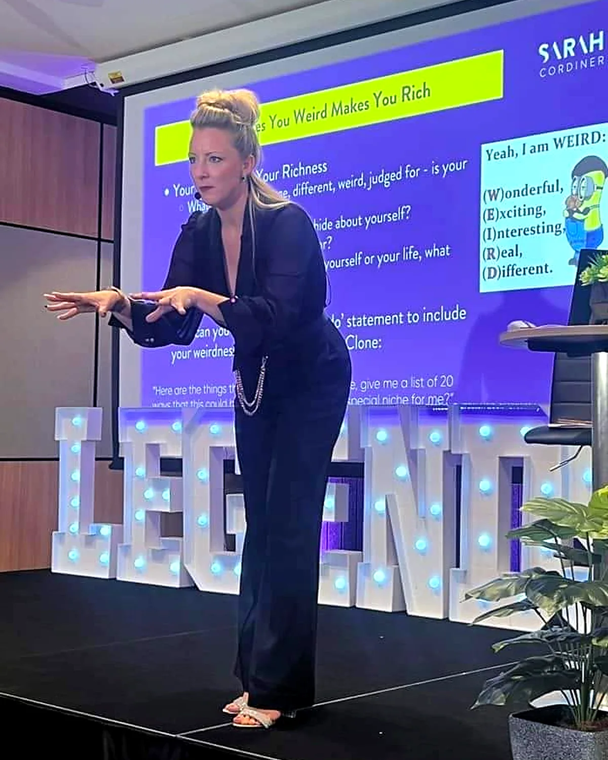 Sarah Cordiner teaching on stage in front of the LEGENDS light-up letters