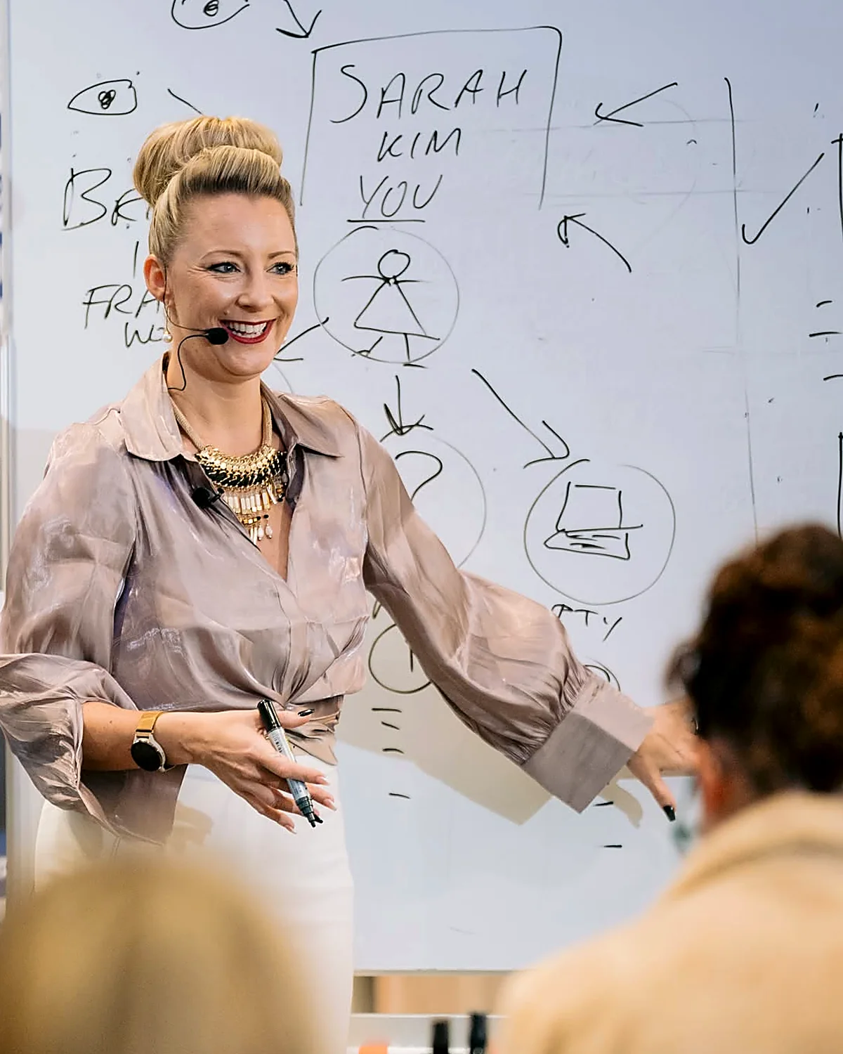 Sarah Cordiner smiling while teaching at a whiteboard